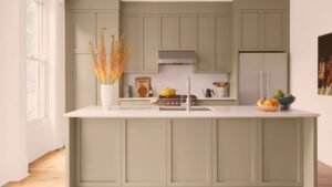 Kitchen island and surrounding cabinets in a muted neutral finish
