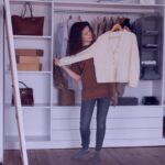 full shot woman holding sweater Smart Mudroom Closet Ideas for your Small Spaces in Dallas